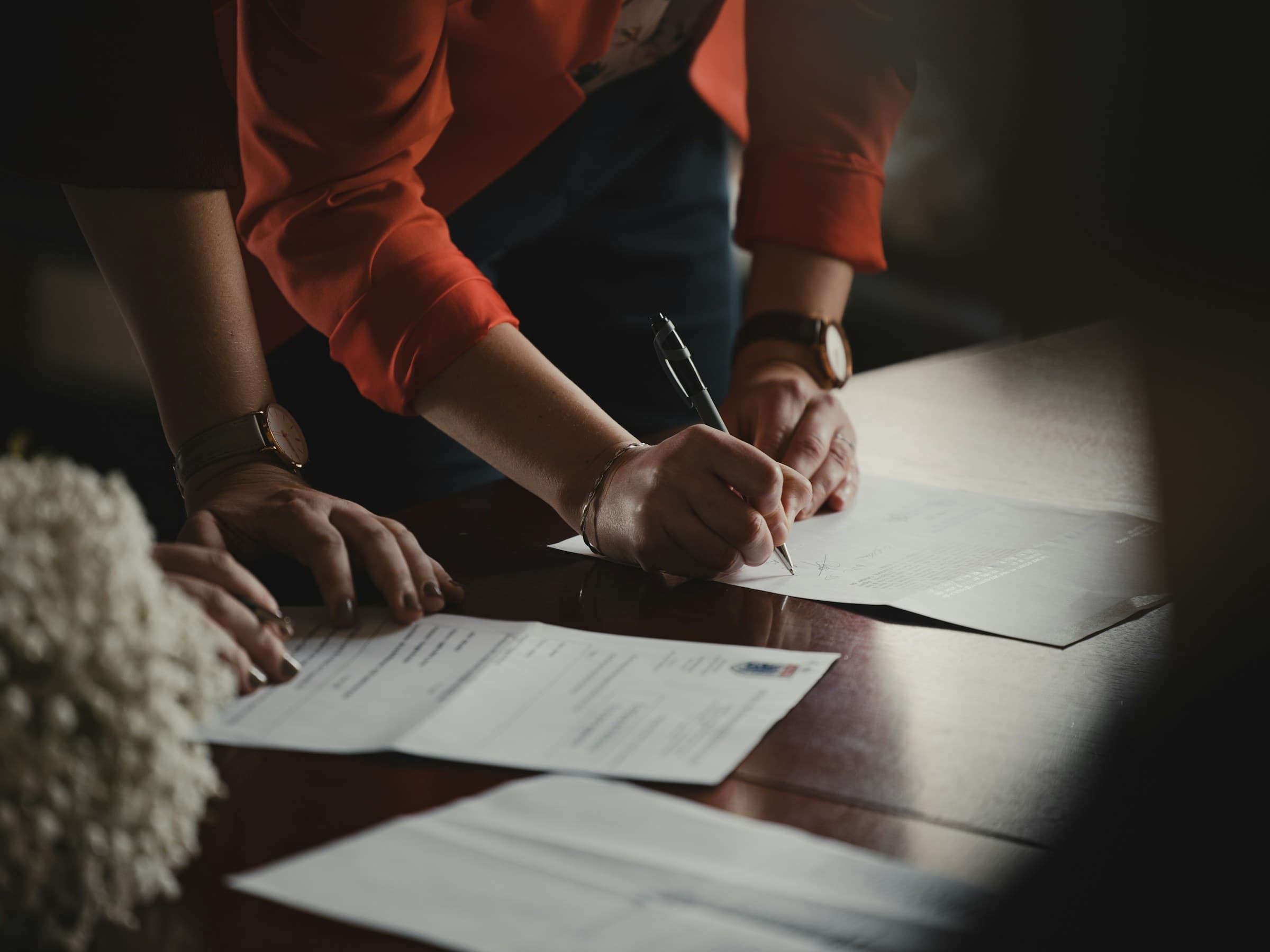 A contract meeting in a formal room, working table, no handshake