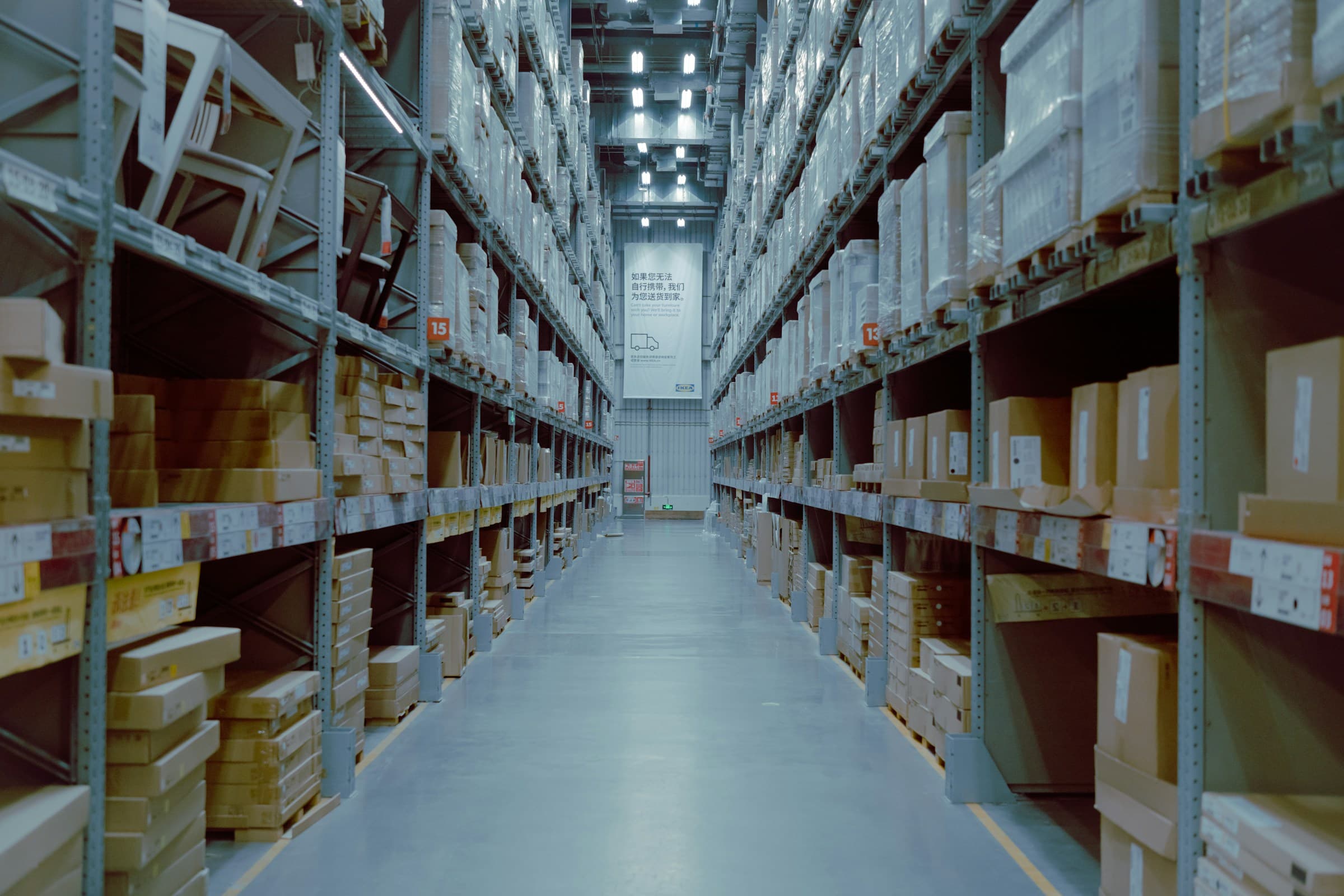 A sourcing warehouse aisle, racking and pallets, no close faces